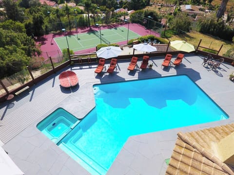 Aerial view of private pool deck & tennis court