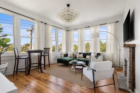 Bask in sunlight and sweeping views of Colonial Lake and downtown Charleston from this bright, stylish retreat—complete with a velvet sofa, warm wood floors, and a cozy fireplace that makes it feel like home.
