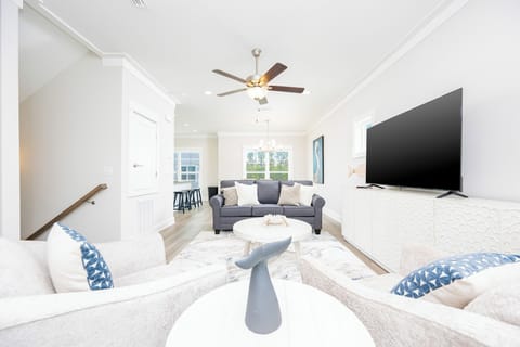This inviting living area features a stylish gray sofa, a large TV, and a cozy atmosphere perfect for relaxation