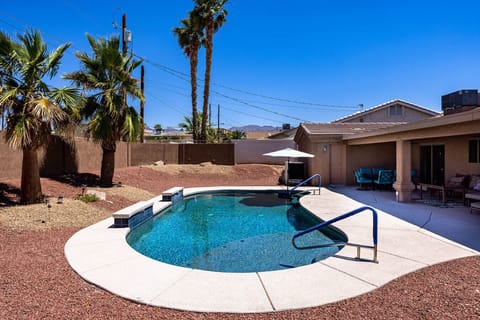 Unwind in a fully fenced backyard featuring a crystal-clear pool and plenty of space to lounge under the umbrella