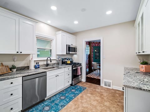 A bright and airy kitchen, perfect for cozy mornings and delicious dinners. Sunshine streams in, illuminating the gleaming white cabinets and the vibrant rug. ✨ #homegoals