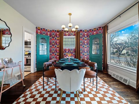 A symphony of style! The bold wallpaper, cozy chairs, and stunning view create a truly unique space.