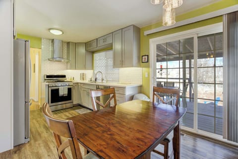 Warm wood dining table beside a bright, streamlined kitchen—set out breakfast, prep and cook with everything close at hand, then slide the glass door open for easy back-and-forth between meals and fresh air.