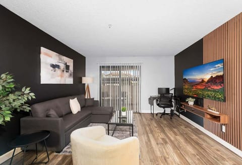 Modern living room, dedicated working space, TV, plush couch, and sofa bed