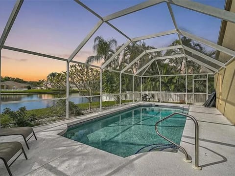 Serene screened pool patio with tranquil water views at sunset