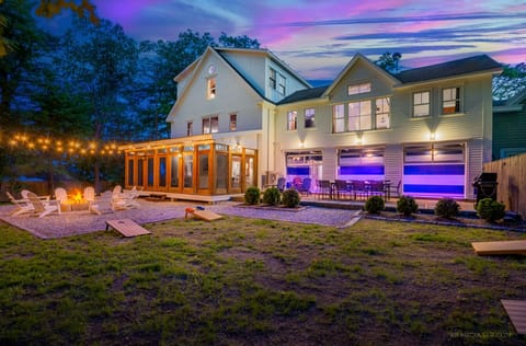 Beautiful backyard with fire pit, string lights, and a bright screened porch.