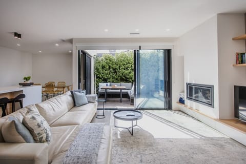 Open plan kitchen living and dining flowing onto the courtyard deck. Indoor atrium across 2 levels