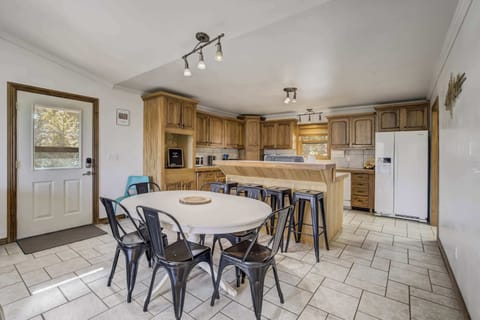 Gather around the dining table in this inviting open-concept kitchen, fully equipped for home-cooked meals and memorable moments.