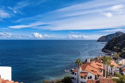 Stunning coastal vista showcasing dramatic cliffs, azure waters, and charming Mediterranean-style buildings nestled along the rugged shoreline.
