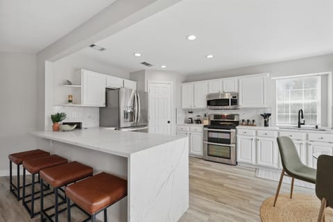 With classic white cabinets, stainless steel appliances, and plenty of space, this fully equipped kitchen has everything needed to inspire your culinary creativity. 