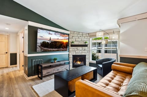 Shore Suite living room with a cozy gas fireplace and massive 75-inch smart TV. 