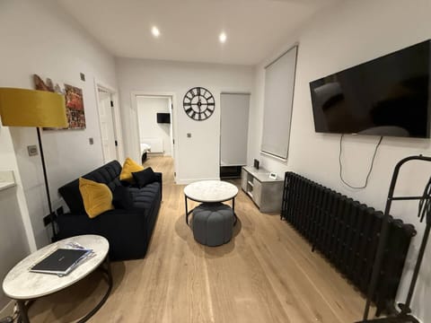 Bright modern living room with smart TV, comfy sofa, and cozy ambiance