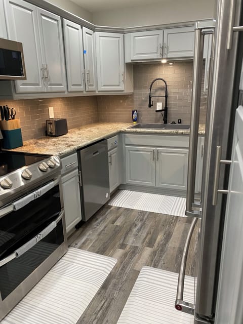 fully stocked kitchen w/ electric stove, full size refrigerator and microwave ov