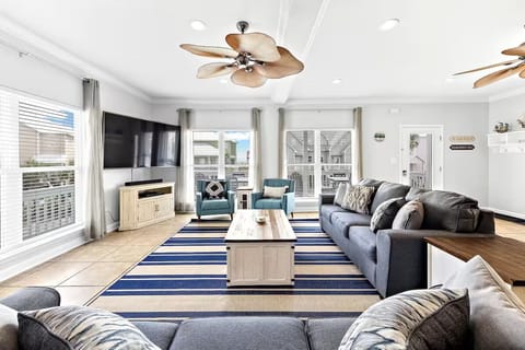 Bright, stylish living room with cozy seating, smart TV, and a cozy vibe