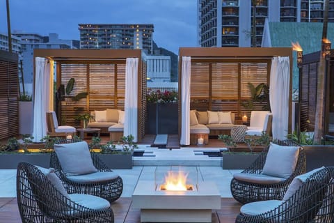 Lounge by the rooftop fire pit as the city glows.