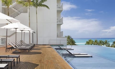 Dive into an ocean-view infinity pool with plush loungers.