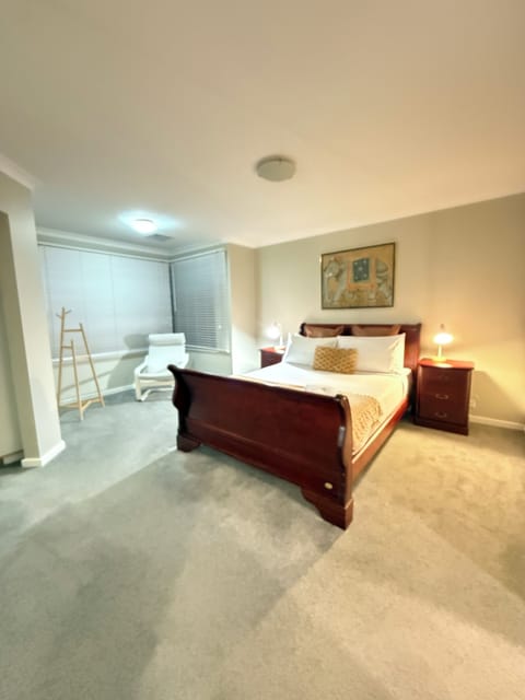 Escape to your stylish and serene bedroom retreat. This bright, airy room features a cozy bed with fresh linens, a nightstand, and a warm lamp; perfect for unwinding.