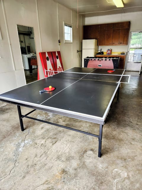 Ping pong table, foosball and corn hole in garage