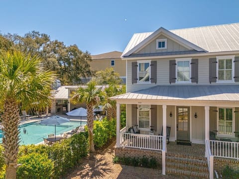 Two-story property exterior with metal roof and palm trees
