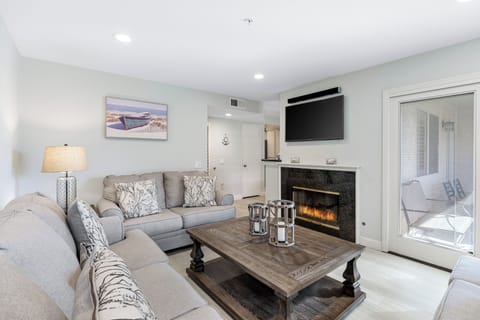 The inviting living room features a television, fireplace, and a queen-sleep sofa.