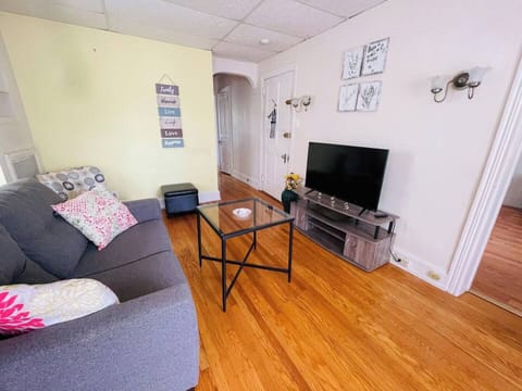 The living room comes furnished with essential pieces, including a comfortable sofa, a coffee table, TV stand, and dining table, providing immediate comfort upon move-in.
