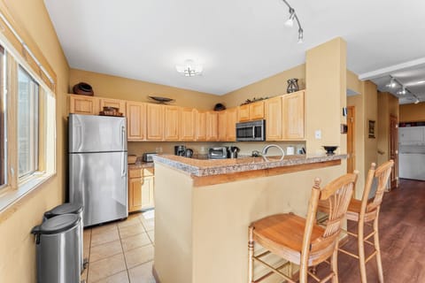 Full kitchen with stainless steel appliances, and breakfast bar seating 2 for casual dining.