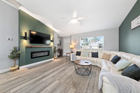 Accent wall tv mounted w/ insert fireplace with reclining sofa to feel like home