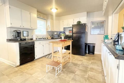 Kitchen has island, gas stove, microwave, dishwasher, coffee maker, fridge, more
