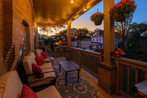 Warm Evenings, Glowing Porch – The wraparound porch sets the mood with string lights, cozy seating, and historic charm that invites you to linger a little longer.
