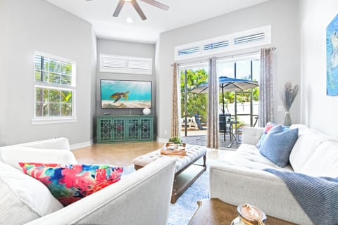 Lounge in a sun-filled space with cozy seating and direct access to the patio for indoor-outdoor comfort.