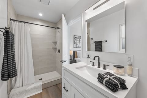 This stunning renovated bathroom boasts a walk-in shower, complete with a vanity with ideal lighting to elevate your morning routines