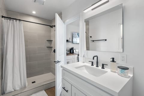 This stunning renovated bathroom boasts a walk-in shower, complete with a vanity with ideal lighting to elevate your morning routines