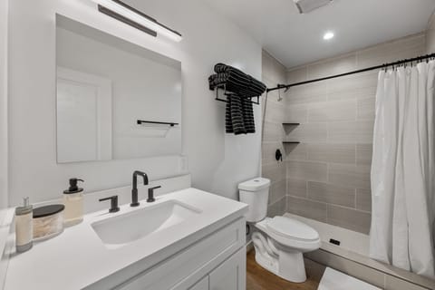 This stunning renovated bathroom boasts a walk-in shower, complete with a vanity with ideal lighting to elevate your morning routines