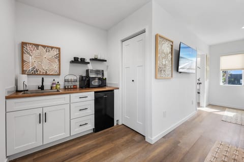 This modern, well equipped kitchenette with a small fridge, microwave, toaster oven/air fryer combo, and Keurig coffee maker -perfect for effortless meals and morning coffee with a small nook seating for two.