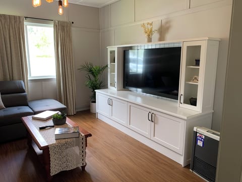 Lounge room with pull out sofa, gas heater, games in tv cabinet, large smart tv