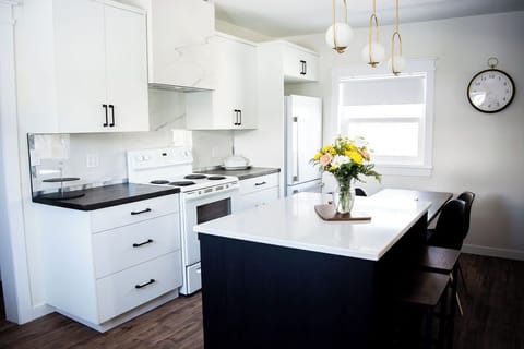 New customer kitchen with modern amenities, quartz counters and wooden table