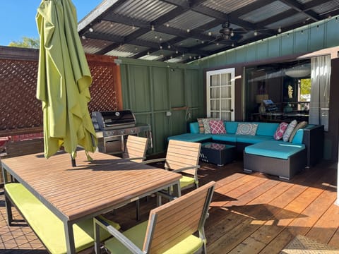 The covered back deck is outdoor living at its best! A BBQ, cozy seating, views, and a dining area.