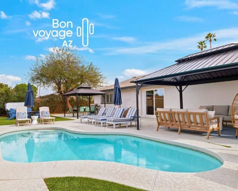 Resort-style backyard with heated pool, hot tub, fire pit, shaded gazebos, and sun loungers, designed for total relaxation.