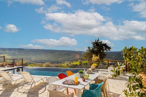 Traditional stone hued patio and dining area next to the pool