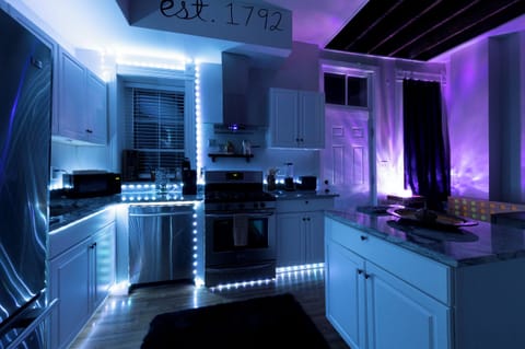 Kitchen: Modern space with vibrant lighting, stainless steel appliances.