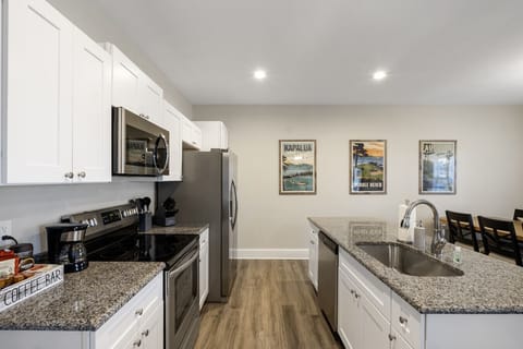 Fully equipped modern kitchen with stainless steel appliances, granite countertops, and ample space.