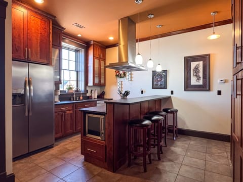 Custom designed kitchen with granite island and island seating to enjoy family cooking with all the extra kitchen amenities at Tamm Loft.