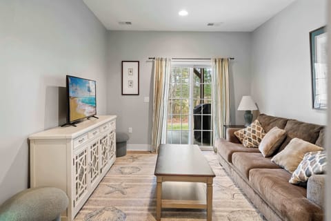 Cozy family room with a plush sofa, TV console, and patio access