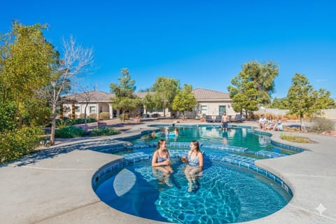 Dive into fun in this resort-style backyard! Enjoy the sparkling private pool and relax in the adjacent hot tub. With a spacious patio perfect for lounging and lush palm trees providing a tropical setting, this is the ultimate spot for group fun.