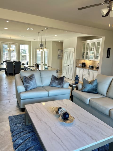 Large living room with 65 in smart Tv and leather sofas .