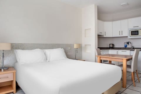Studio-style room blending sleeping and kitchen areas, designed for convenience and comfort.