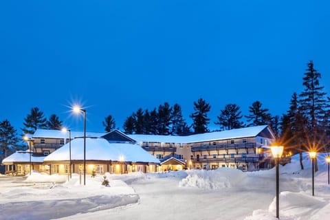 Unwind under snowy skies as the lodge glows warmly at night