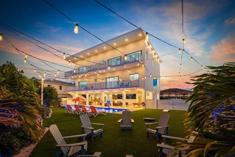 Spacious backyard featuring a large pool, relaxing jacuzzi, outdoor kitchen, and fun games for everyone!