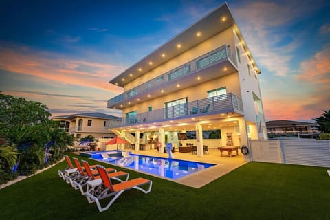 Spacious backyard featuring a large pool, relaxing jacuzzi, outdoor kitchen, and fun games for everyone!