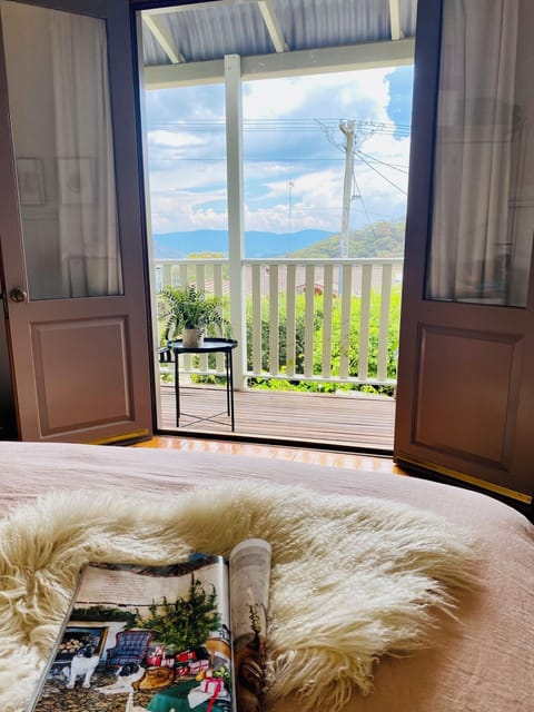 The main bedroom opens out onto the verandah, with views of the Kanimbla Valley.